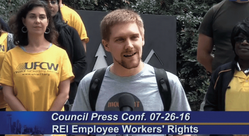 REI worker Collin Pointon speaking outside REI headquarters in Seattle during the REI campaign’s “victory” press conference celebrating the wage hike