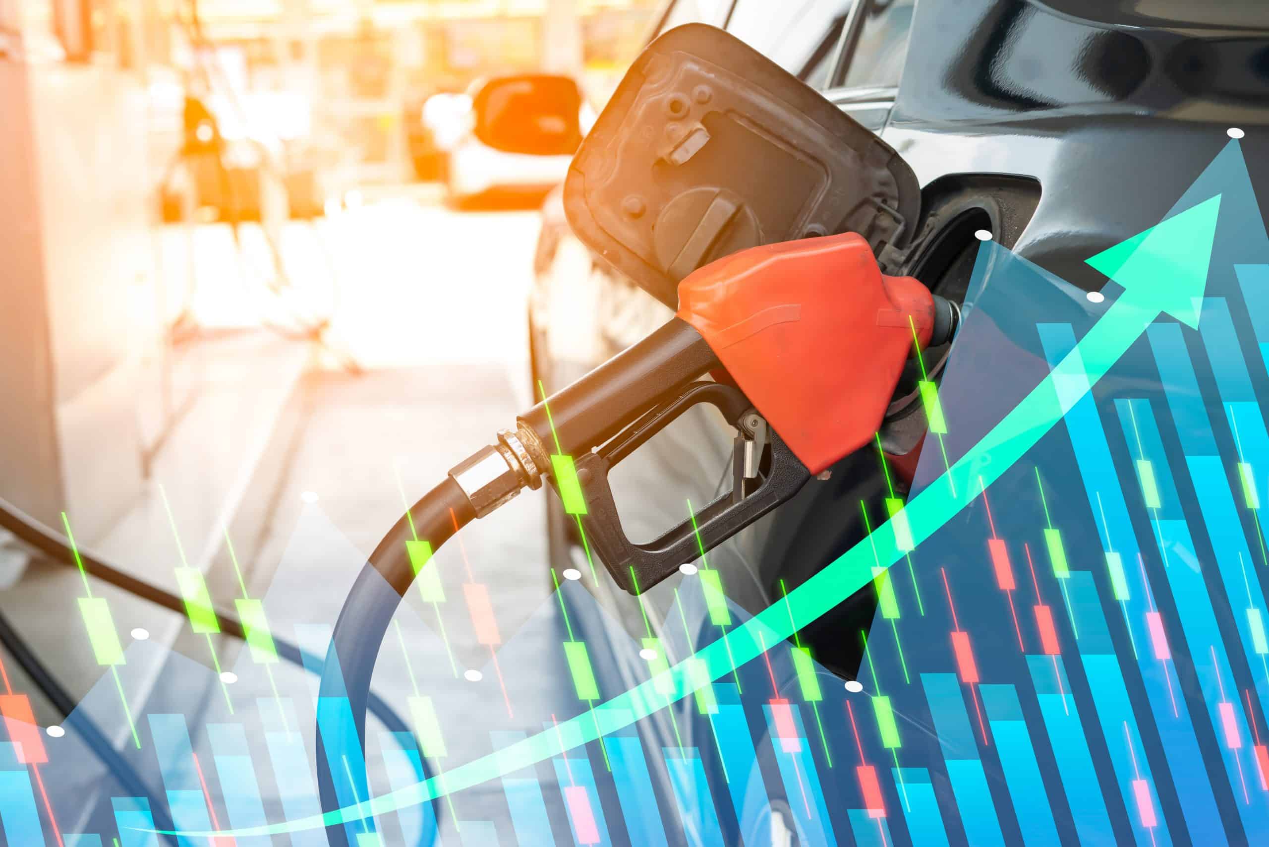 Close up of fuel monitoring system refueling a petroleum to vehicle and graph chart with the indicator on the oil price slide at gas station. Concept fluctuations in oil prices and exchange trade.